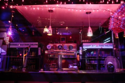 A photo of a dimly lit tallulahs bar. An unattended counter with three handles for beer on tap